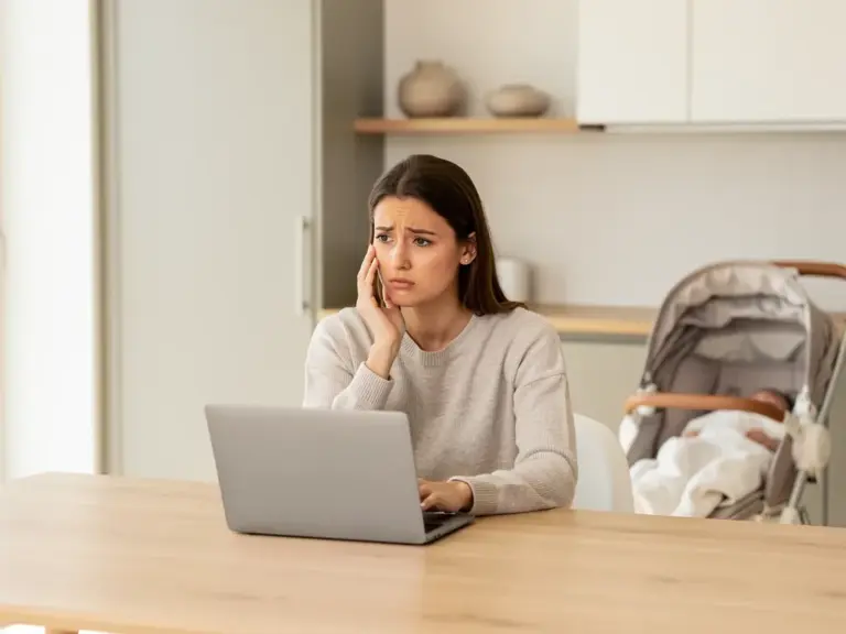 Wie Elternzeit den Anspruch auf Arbeitslosengeld beeinflusst Eltern mit Baby und Laptop informieren sich zu Arbeitslosengeld und Elternzeit
